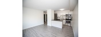 A kitchen with a white island and stainless steel appliances.